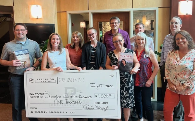 Precision Capital team presenting a donation check from The Integrity Foundation